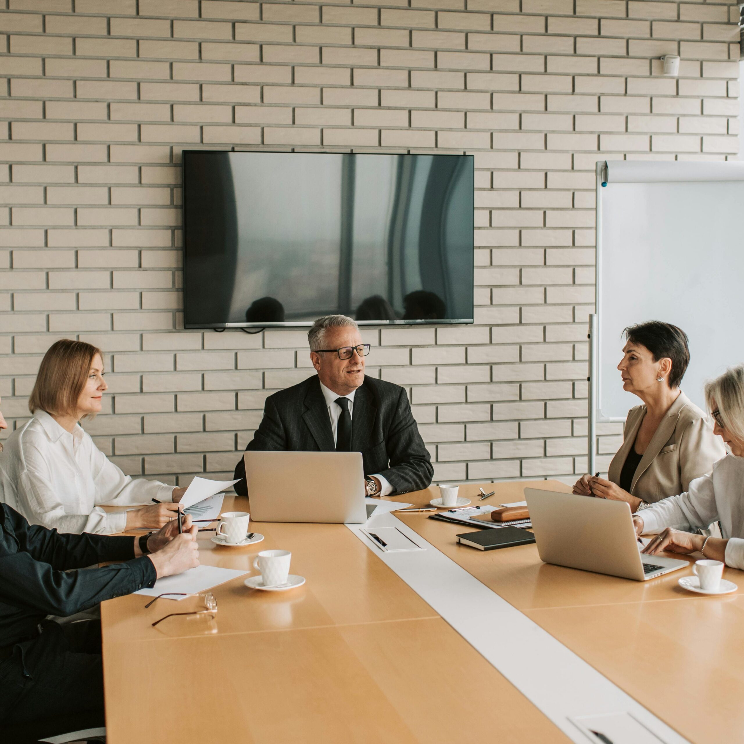 A professional team meeting with laptops and documents in a modern office.